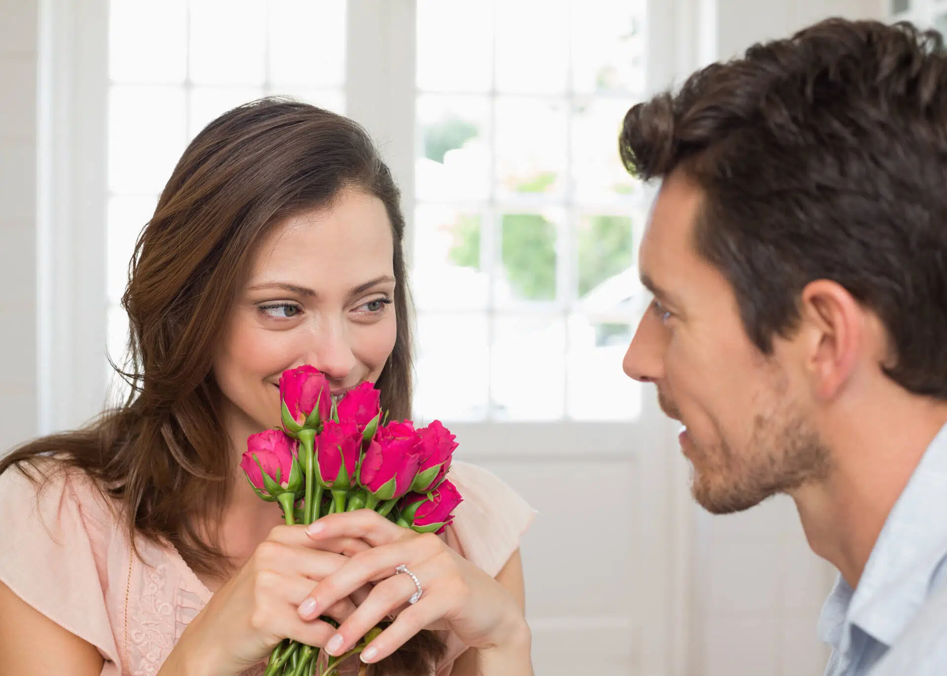 man lovingly looking at a woman with flowers